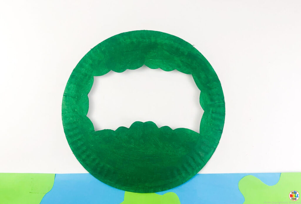 paper plate painted green with middle section cut out to resemble bushes for adam and eve paper plate craft for kids